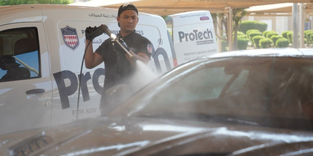A ProTech washer cleaning a car next to the ProTech car wash van